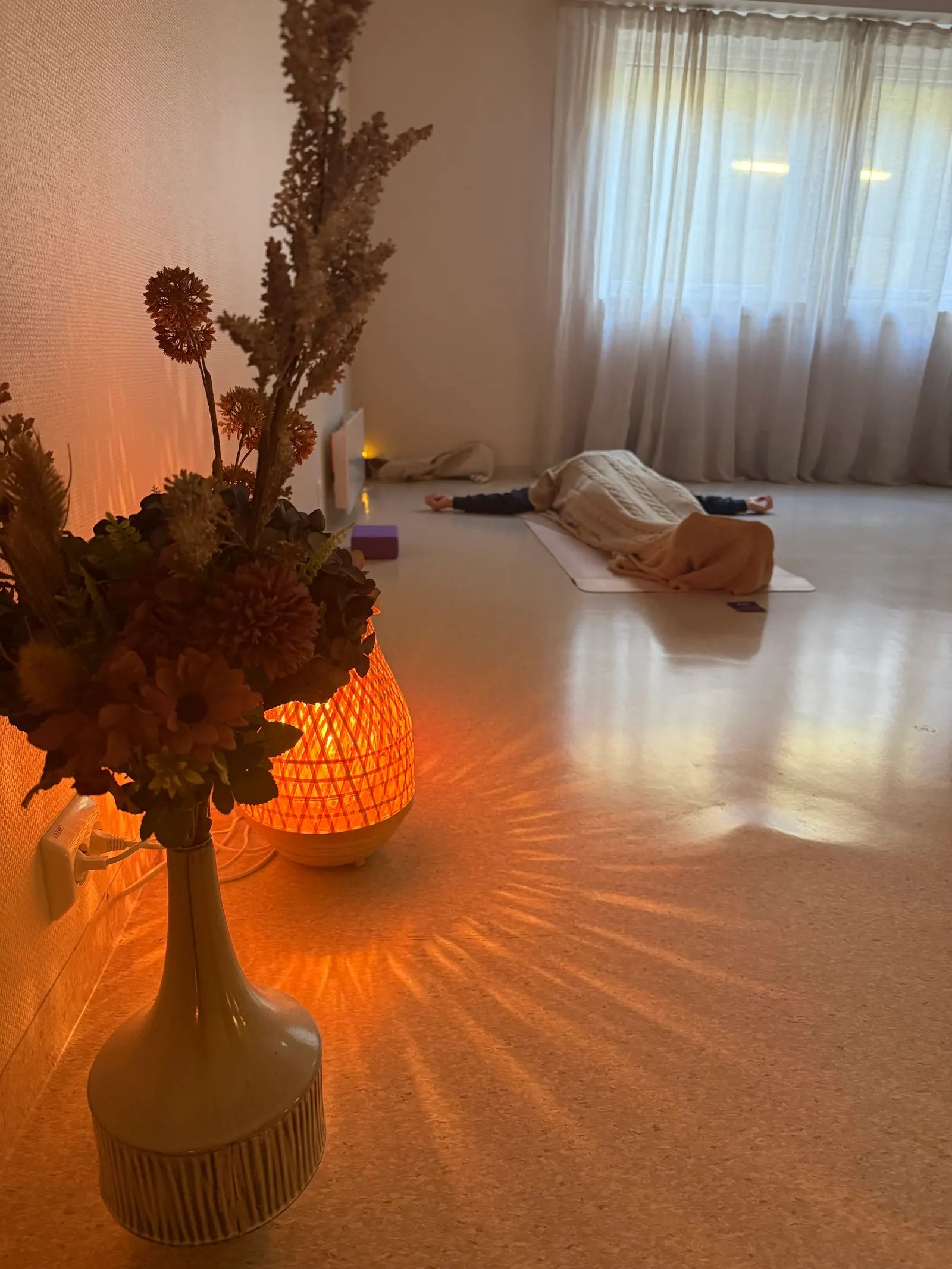 Stilleben med lykt og tørkede blomster i studioets varme lys