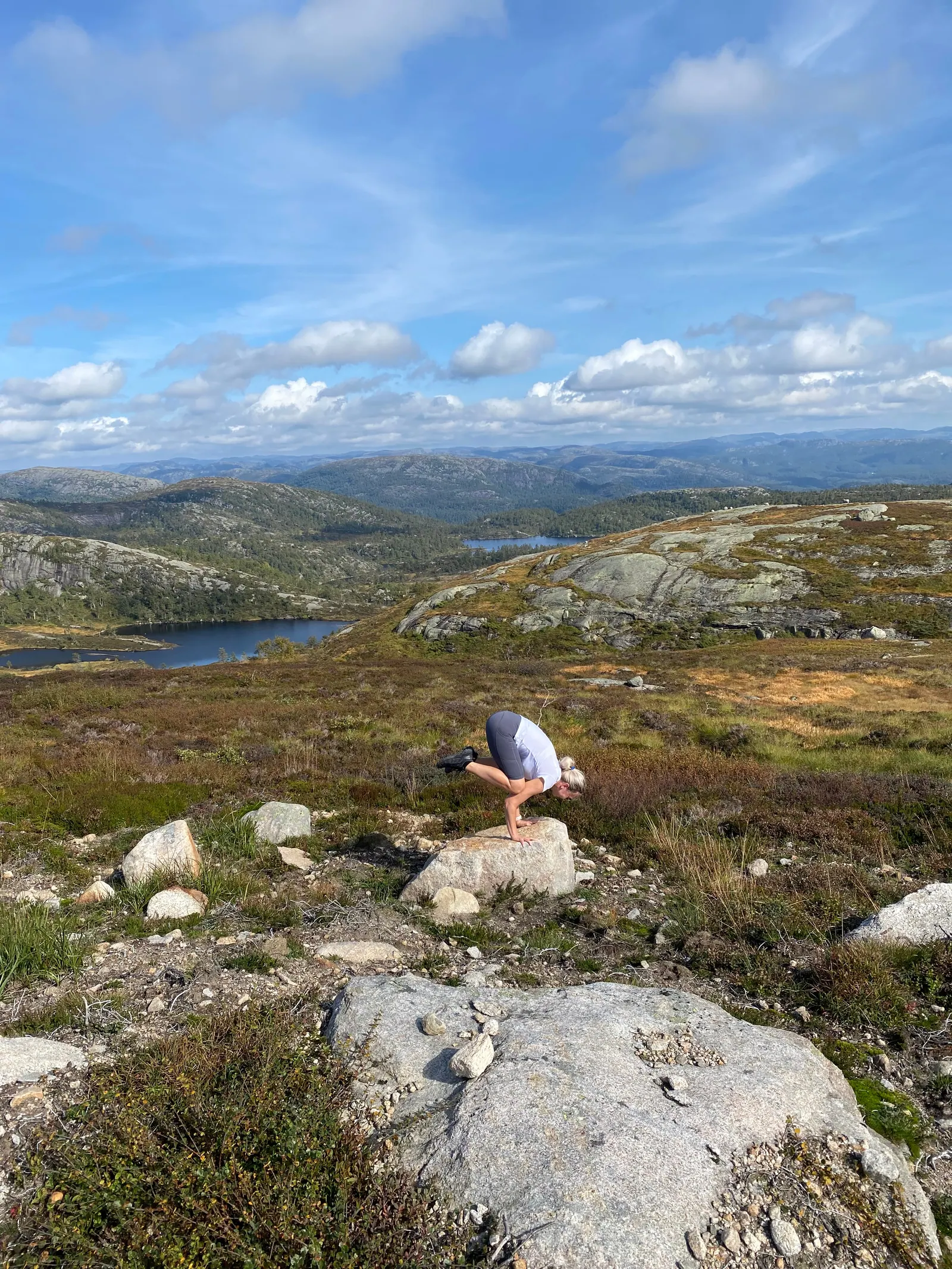Bakasana balansert på en stein i et åpent viddelandskap