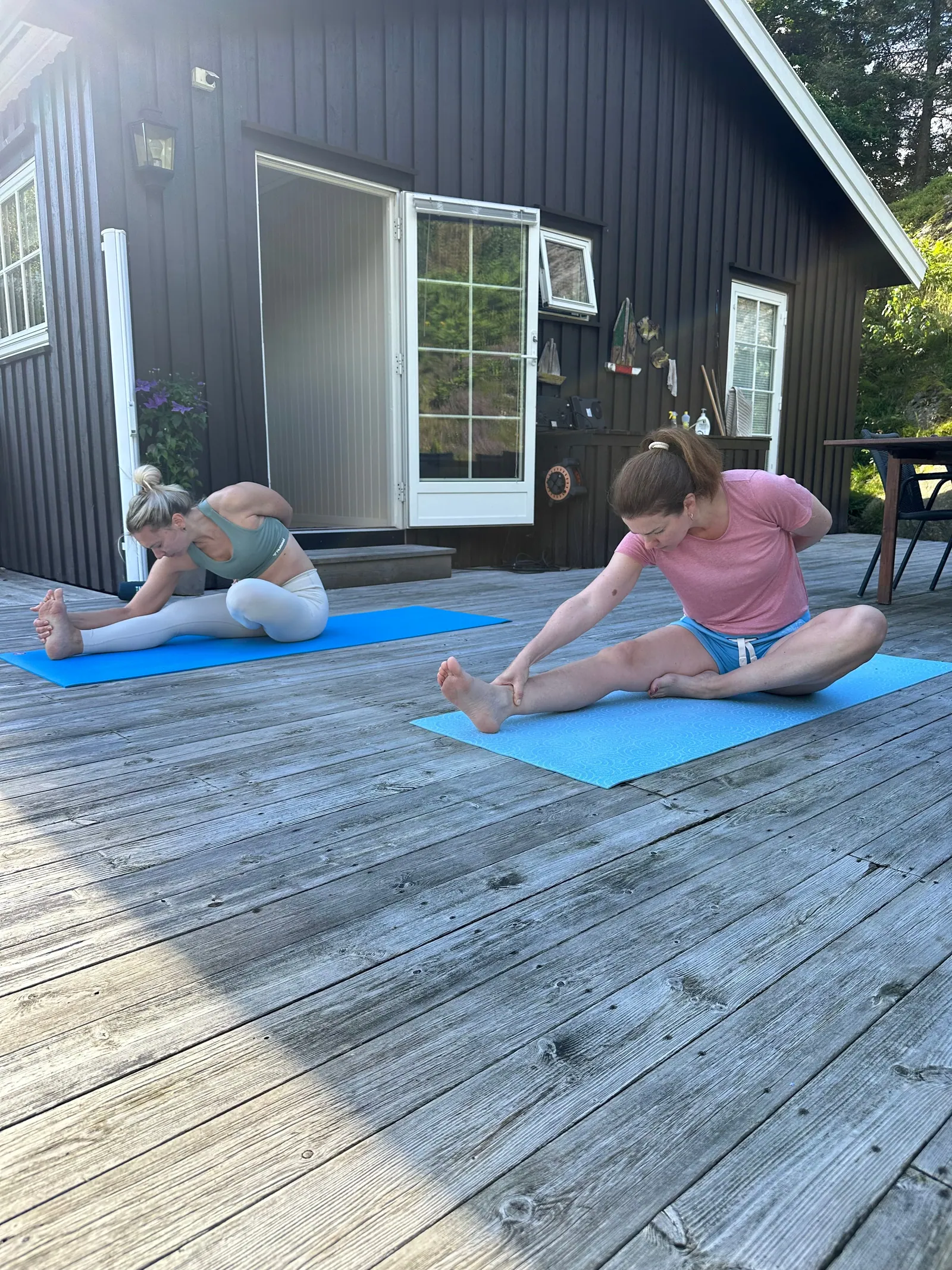 Forward fold på matter på terrassen i sommerlig hagelys